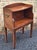 A mid 20th Century rich reddish brown mahogany bedside table nightstand. The design features two tiers: an open shelf area...