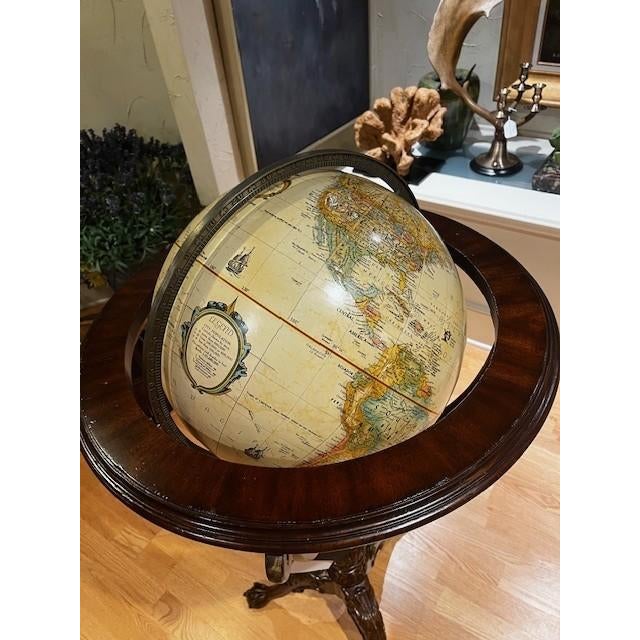 Handcrafted globe from Maitland Smith. Dark brown wood, globe in color.