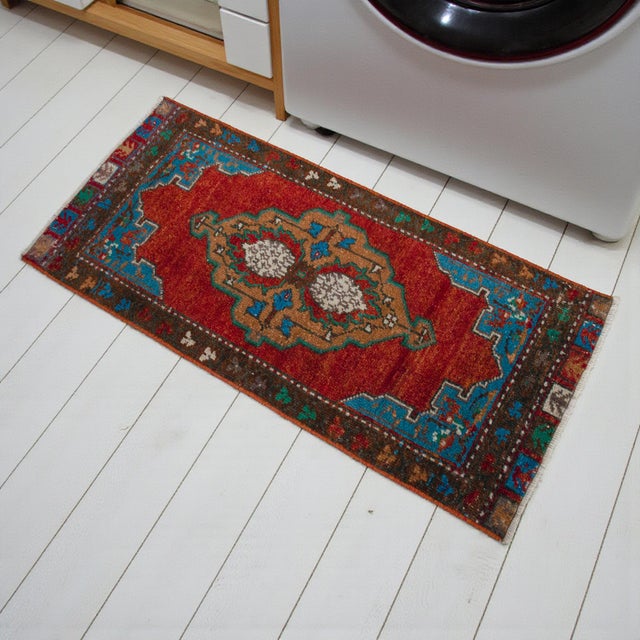 Vintage Turkish hand-knotted small rug from Oushak (Aegean), circa 1970, featuring warm rust-red tones and authentic...