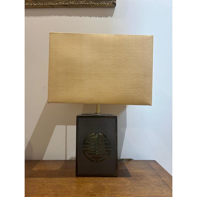 An elegant table lamp dating from the 1970s, characterized by a steel structure combined with brass elements, offering a...