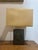 An elegant table lamp dating from the 1970s, characterized by a steel structure combined with brass elements, offering a...