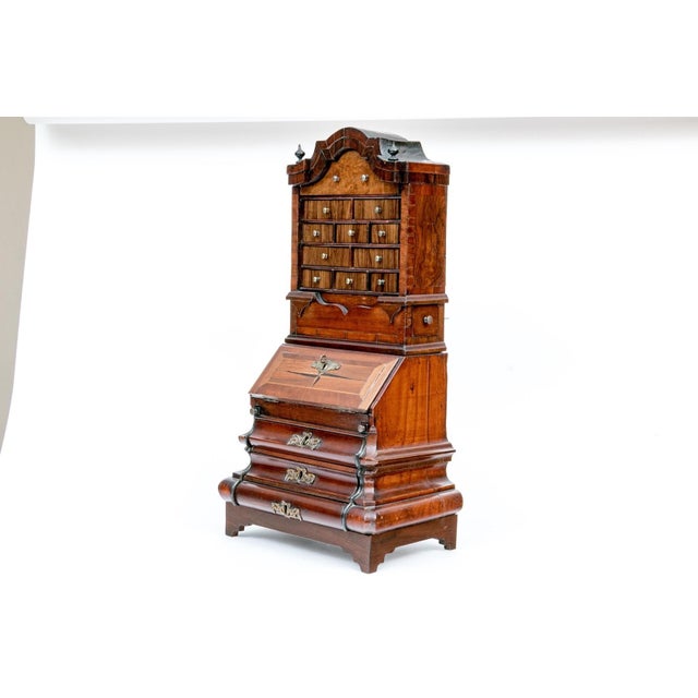 A late 18th century salesman sample of an English walnut secretary bureau bookcase with a broken-arch pediment, turned...