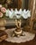 A striking vintage centerpiece featuring a dramatic Bohemian-style opal glass tazza mounted on an ornate cherub pedestal...