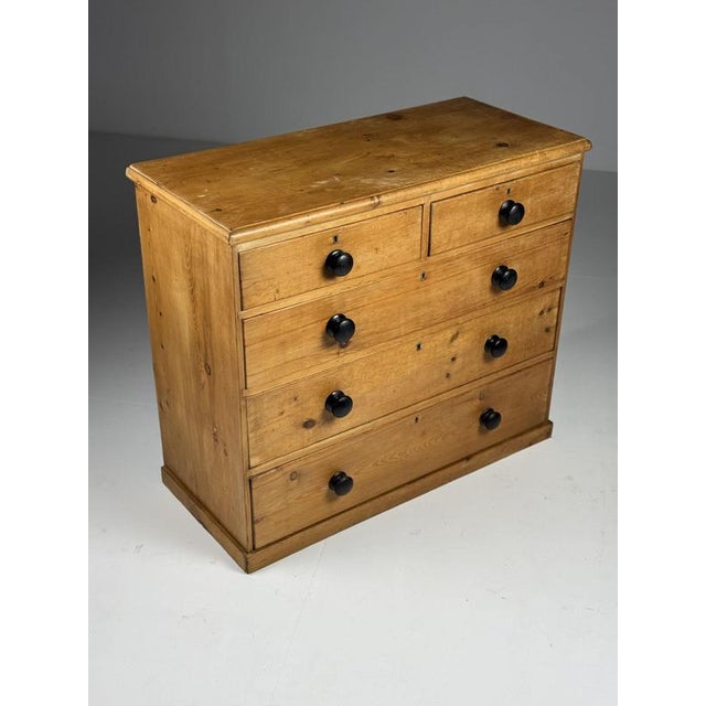 Chest of drawers / Commode. Crafted from solid pine. Originally from England, 19th century. with black wooden knobs....
