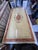 Inlaid dining table with crown decorations and marble pedestal bases. The rectangular top features a central inlay and...