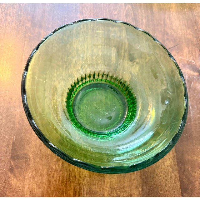 This elegant mid-century emerald green bowl featuring a scalloped rim and ribbed pedestal base was manufactured by E.O....