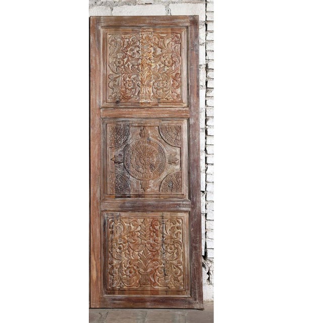 These vintage hand-carved wooden barn doors showcase intricate floral detailing paired with a beautifully aged natural...