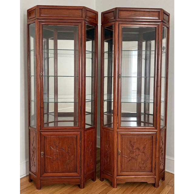 Midcentury pair of Chinese export mirrored back cabinets with brass hardware, thick glass shelving and ample storage....
