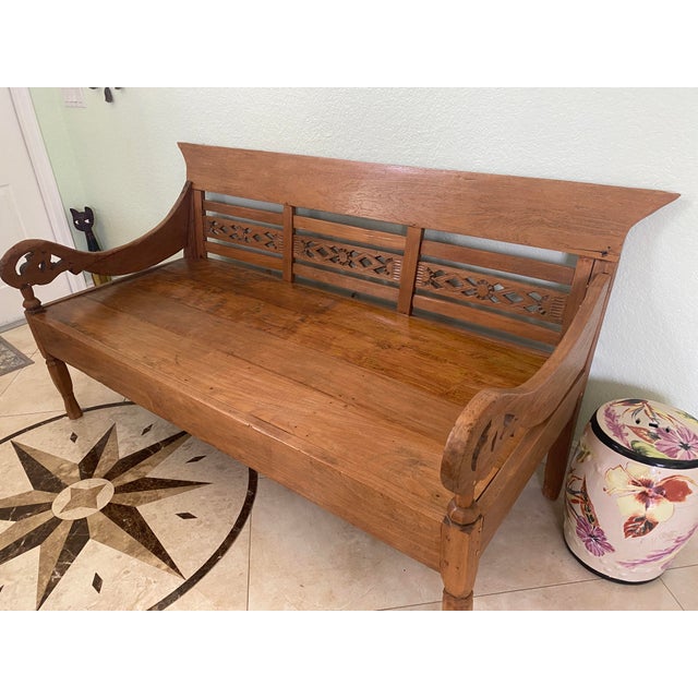 Elegant hand-carved daybed crafted from solid reclaimed teak wood by artisans on the island of Java, Indonesia, and...