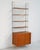 "String" bookcase in teak and lacquered metal with a suspended cabinet with sliding doors and adjustable shelves. String...