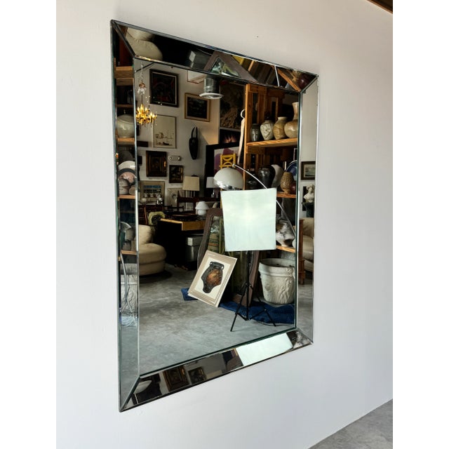 This stunning vintage Hollywood Regency-style wall mirror exudes timeless elegance with its large, beveled glass panels...