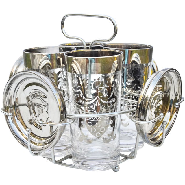 Gorgeous midcentury drink set including four hand-painted glasses with an ornate silver motif and four coasters, housed in...