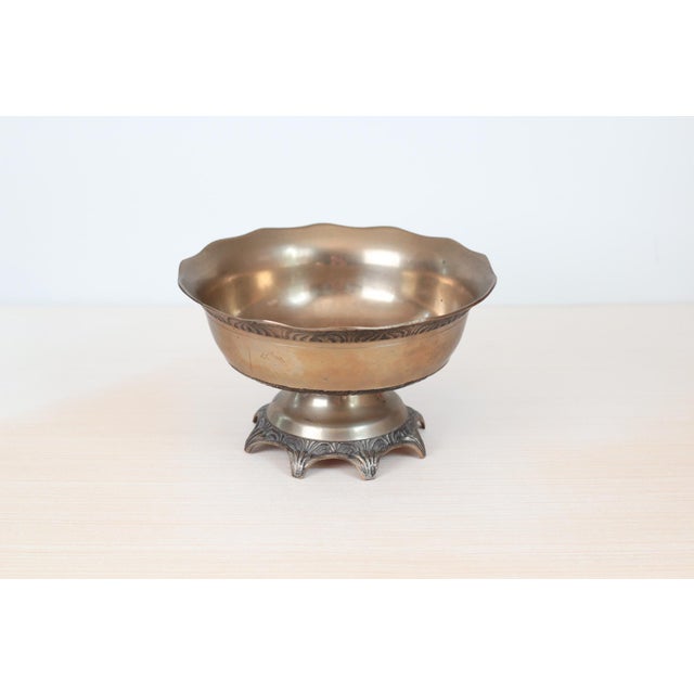 This vintage solid brass pedestal bowl features a scalloped rim, ornate etched detailing, and a rich patina. Substantial...