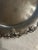 Vintage silver-tone serving platter featuring a richly detailed grapevine border with sculpted clusters of grapes and vine...