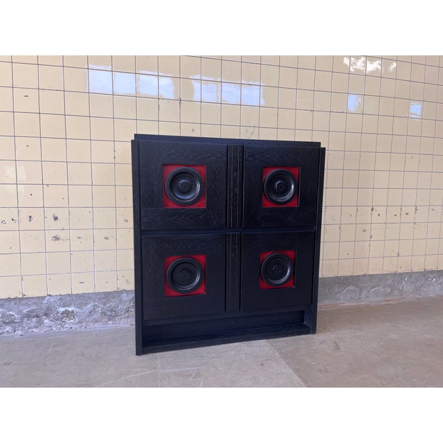 This striking vintage cabinet in brutalist style features a bold and graphic design in black with distinctive red details....