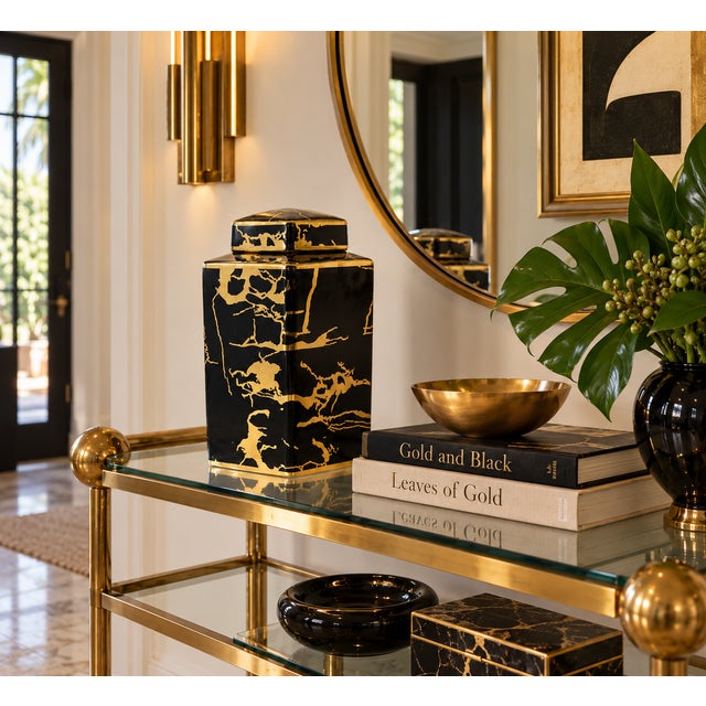 Striking hexagonal black ceramic lidded jar featuring an expressive, irregular gold pattern over a glossy black ground....