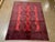 Vintage Hand-knotted Afghan Khal Mohammadi rug with eight geometric guls on a red field and dark navy details. Multiple...