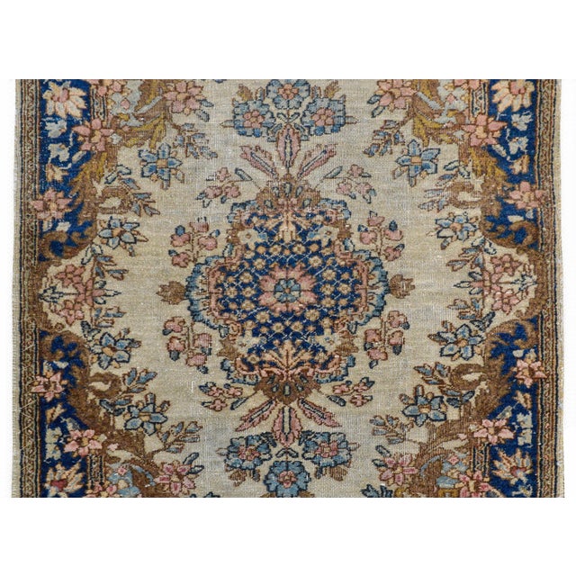 A wonderful early 20th century Persian Kirman rug with a large central floral medallion woven in traditional Kiram colors...