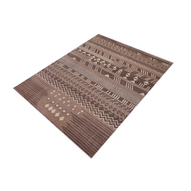 Elevate your interior with this hand-knotted high-low wool area rug, designed to bring depth and dimension to any room....