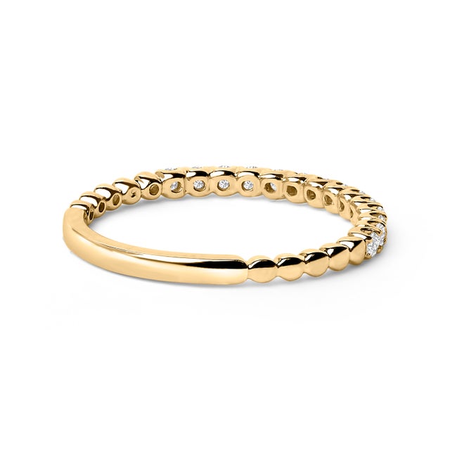 Immerse yourself in the effortless elegance of this exquisite wedding band, masterfully crafted from 14K yellow gold with...