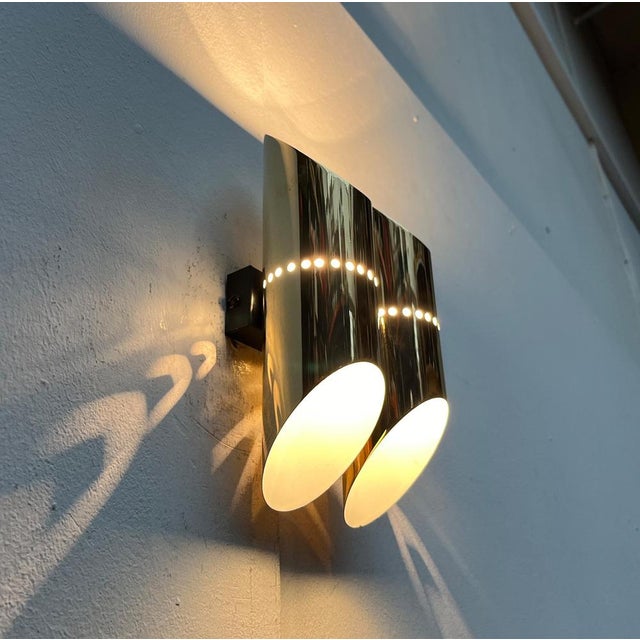 Rare Space Age wall lamp. Two tubes cut on both sides are arranged parallel on a black base. There is a burning point in...