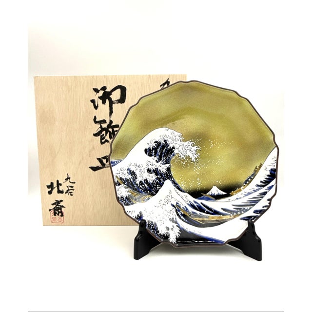 This large Kutani porcelain decorative plate presents a refined interpretation of the iconic “Great Wave,” inspired by the...