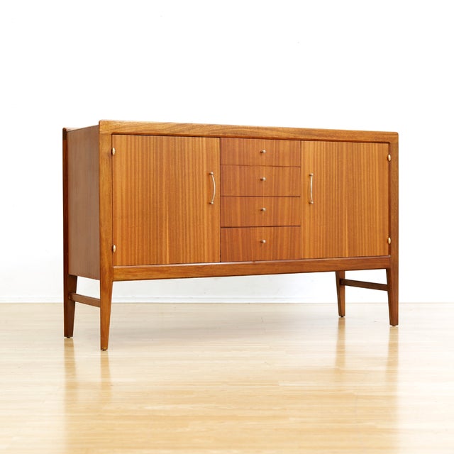 This vintage mid-century credenza was designed and manufactured in England during the 1960s. Produced in beautifully aged...
