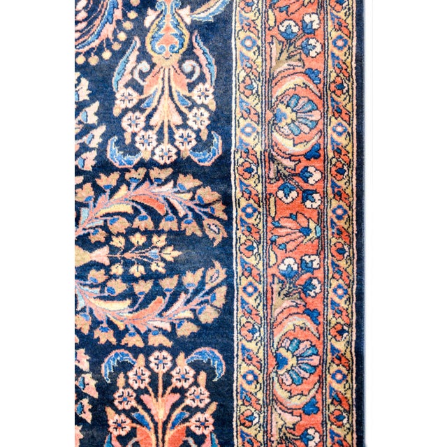 A gorgeous early 20th century Persian Lilihan rug with a dark indigo background, covered by a lacy, multicolored large-...