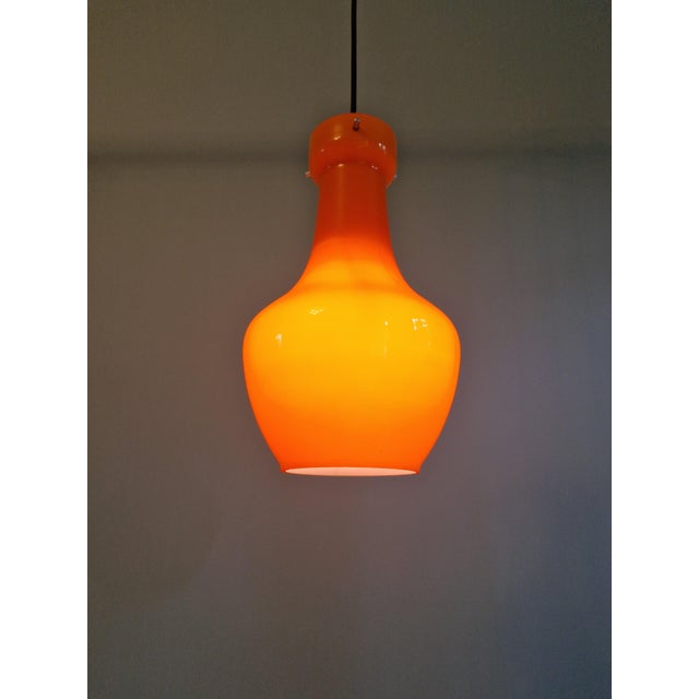 Space age pendant light in orange opaline glass, produced by the italian manufacturer targetti sankey, 1960s-70s....