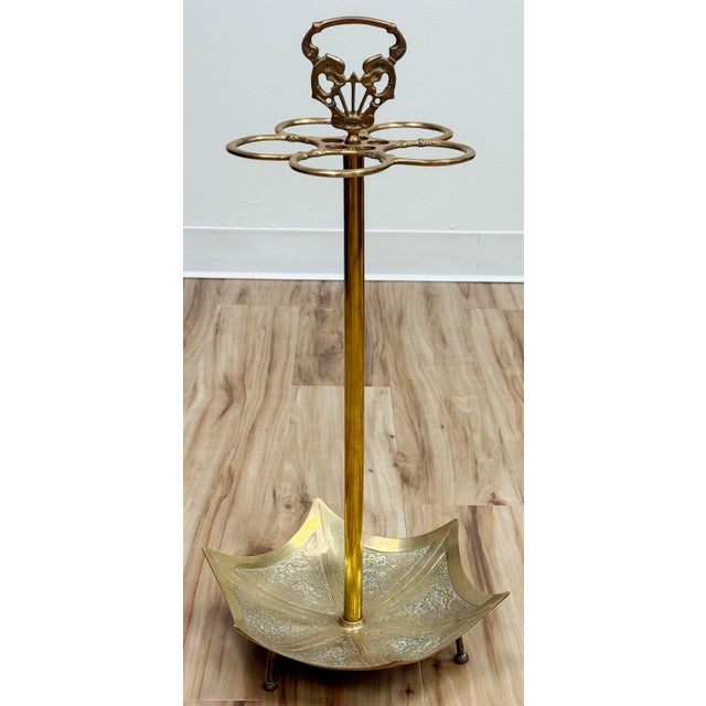 Wonderful vintage brass umbrella stand in umbrella motif with five slots for umbrellas or canes. Koi fish handle. Footed...