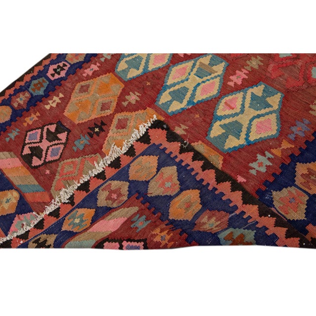 Beautiful kilim handmade wool runner with a rusted field. This Vintage flatweave rug has purple, blue, orange, and brown...