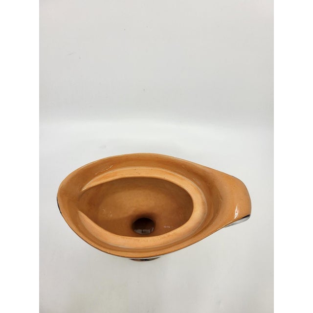 This piece is distinguished by its organic form, asymmetrical lines, and strikingly slender handle. The enamel decoration,...