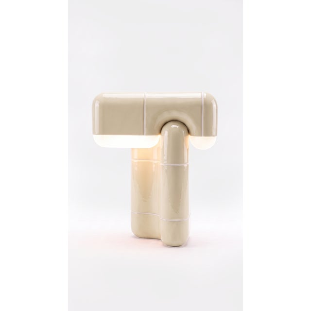 A table lamp that behaves like sculpture. Its folded, tile-built form reads as one continuous gesture, and when the light...