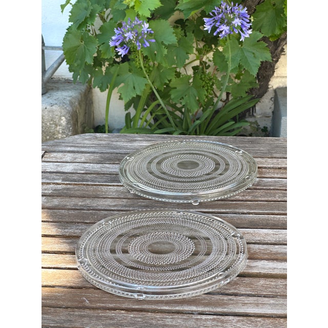 Two large vintage round trivets resting on six molded pressed glass feet with a beaded decoration Dimensions Diameter: 23...