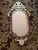 Ornate Venetian style wall mirror features a classic octagonal central pane surrounded by a striking ruby red glass...
