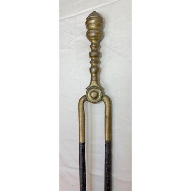 Up for sale is a nice pair of rare antique 18th century wrought iron and brass English fireplace tongs. The arms are...