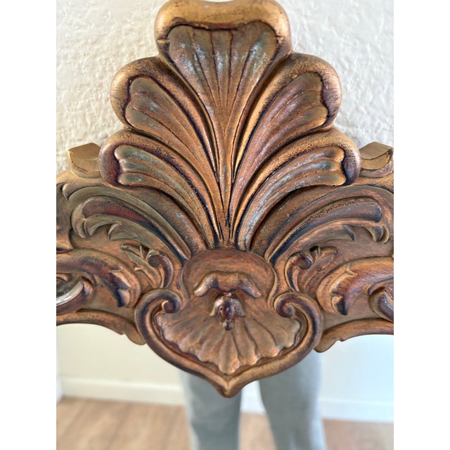 Vintage large rococo French style wall mirror with ornate swirled patterns in a deep antique gold with soft wash of color...