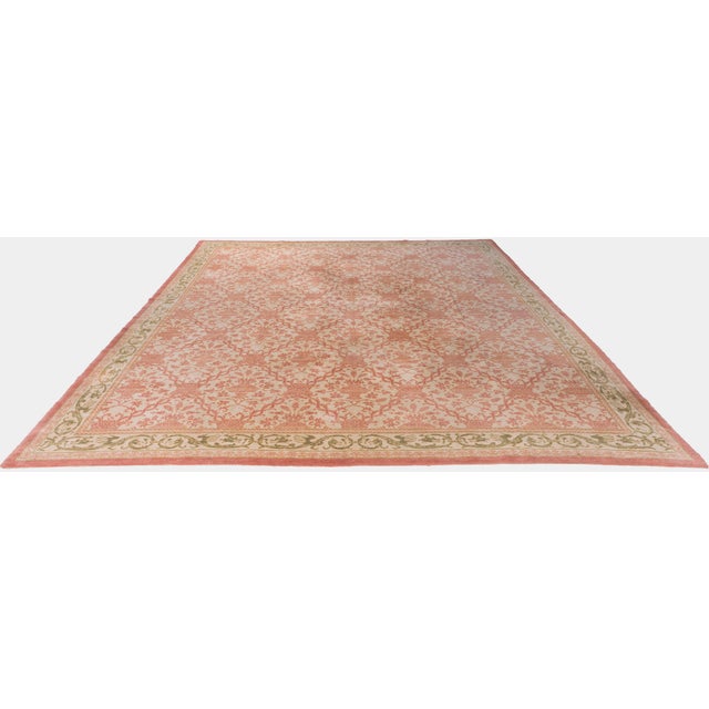 A mid 20th century Spanish style rug, the pale ivory/beige field with an overall pattern in light brick of restrained...