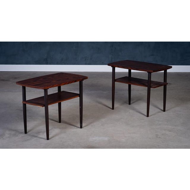 Stylish pair of Danish rosewood side tables from the 1960s. Each table features a lower storage shelf, making them ideal...