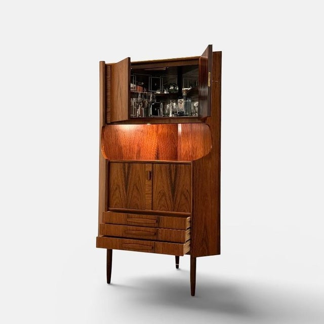 Vintage danish corner bar cabinet executed in richly figured rosewood and produced in denmark during the 1960s. the...