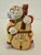 Vintage 1970s clown playing a cello bell. Bisque porcelain.
