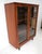 A double door walnut Mid Century bookcase with framed glass doors having solid brass pulls. Two adjustable shelves to the...
