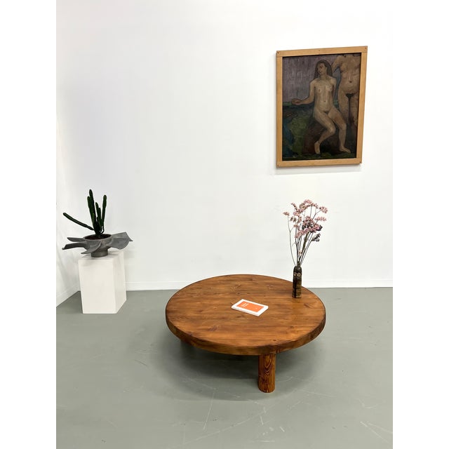 Old coffee table, circular in shape, in solid pine, with its very thick top, resting on three also circular legs. Very...