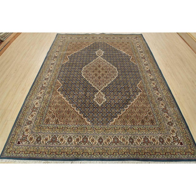 This traditional Tabriz Mahi rug is hand-knotted with an all-wool pile on a cotton foundation. This finely woven oriental...