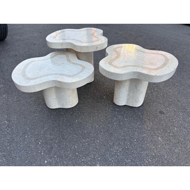 Set of 3 organic-formed tessellated fossil stone cloud nesting tables that form a multi- leveled coffee table. Tables are...