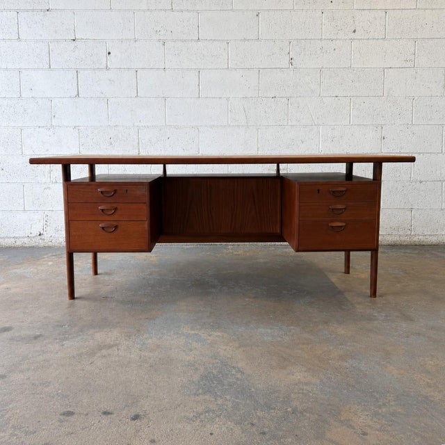 A large Danish teak executive desk by Kai Kristiansen for Feldballes Møbelfabrik, dating to circa the 1960s. The expansive...