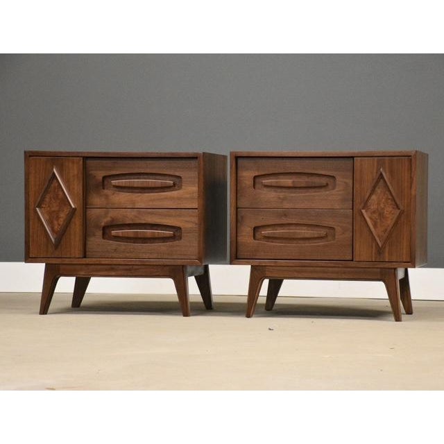 A pair of mid century modern walnut nightstands with burl doors made by Young Manufacturing. Professionally refinished....
