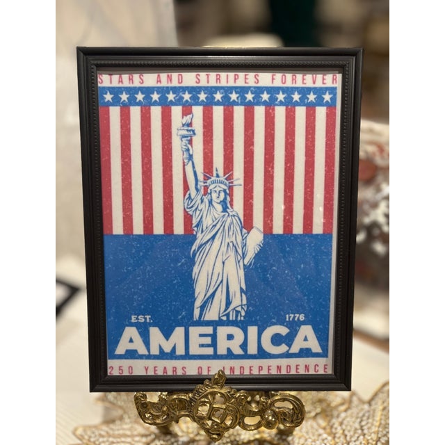 Classic patriotic framed wall art featuring the Statue of Liberty motif. Bold blue and red palette brings Americana style...