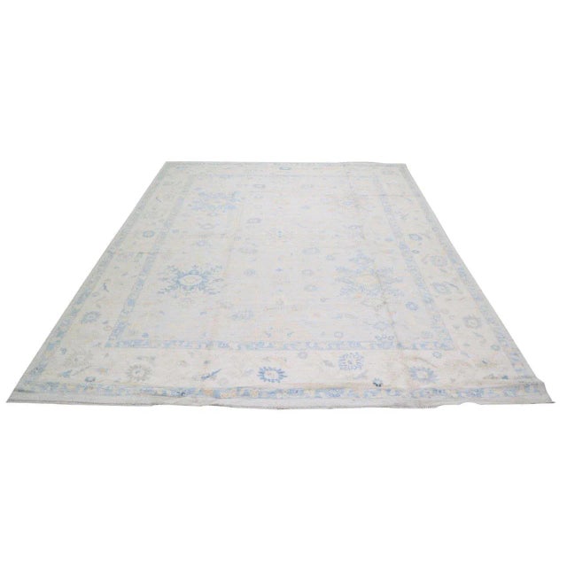 Oushak hand knotted wool rug with fine weave and floral design.