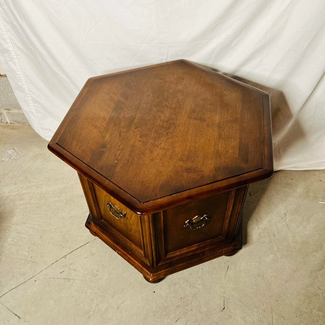 Ethan Allen Mid Century hexagon side table in medium brown finish. 2 doors open to the inside providing ample storage....